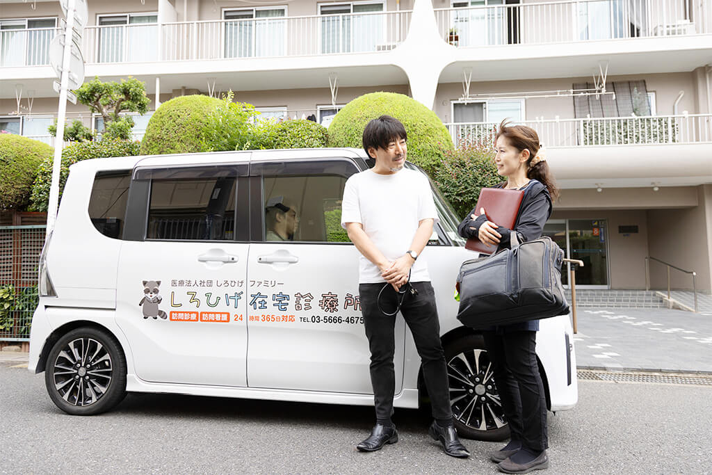 訪問診療車の前に立つ医師と看護師